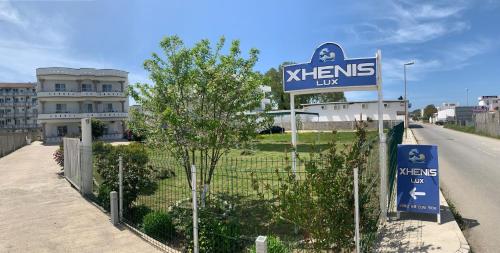 a sign for a xerns lux hotel on the side of a road at Apartmens Xhenis Lux in Ulcinj