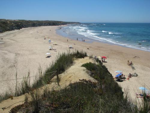 a beach with people on the sand and the ocean at Herdade Moita Mar - Country & Sea in Vila Nova de Milfontes