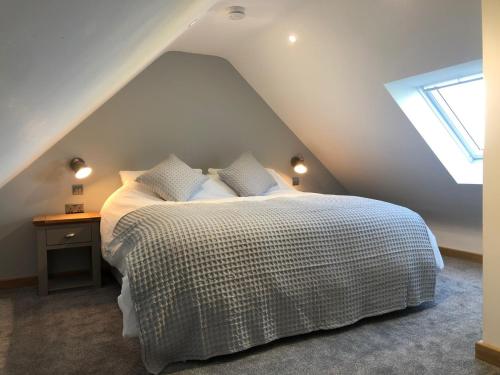 a bedroom with a white bed with a roof at Newly Converted Luxury Barn With Private Hot Tub in Bodfari