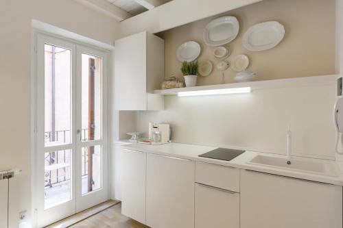une cuisine blanche avec un évier et une fenêtre dans l'établissement Uno splendido punto a Verona!!, à Vérone