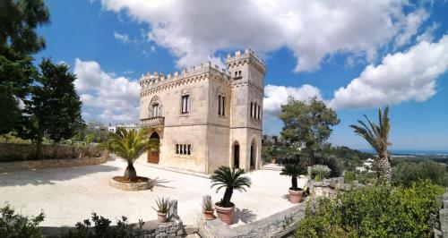 un antiguo castillo con palmeras en un patio en Rocca Giulia, en Ostuni