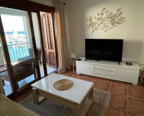ein Wohnzimmer mit Fernseher und Couchtisch in der Unterkunft Villa La Palmeraie Puerto de la Duquesa in Manilva