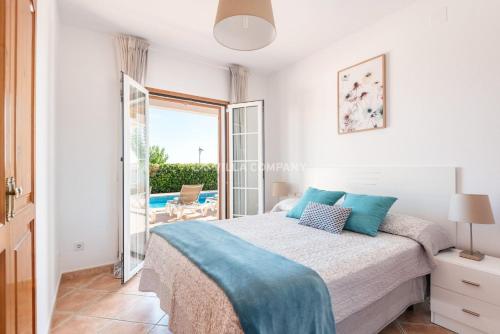 a bedroom with a bed and a view of a patio at Villa BELLAVISTA in Arenal d'en Castell