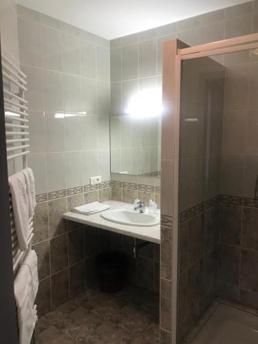a bathroom with a sink and a mirror at Logis Hôtel Restaurant Saint Augustin in Mittelbronn