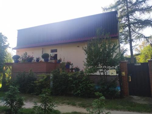 a white house with a black roof at Bed & Breakfast - Warniłęg in Warniłęg
