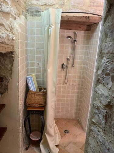 a bathroom with a shower with a basket on a table at Casa del Borgo in Cantiano