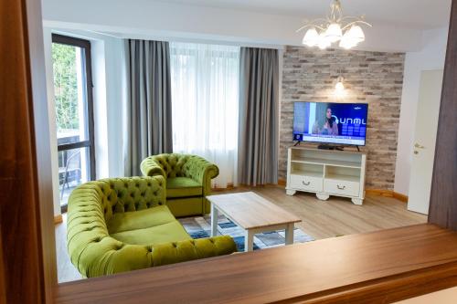 a living room with a couch and a television at Pension Carmen`s Mansion A in Sinaia