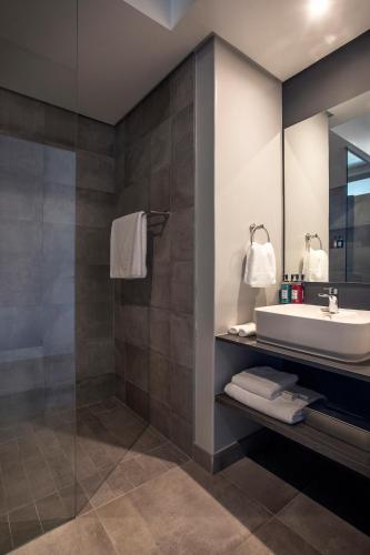 a bathroom with a sink and a shower at The Catalyst Apartment Hotel by NEWMARK in Johannesburg