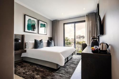 a hotel room with a large bed and a window at The Catalyst Apartment Hotel by NEWMARK in Johannesburg