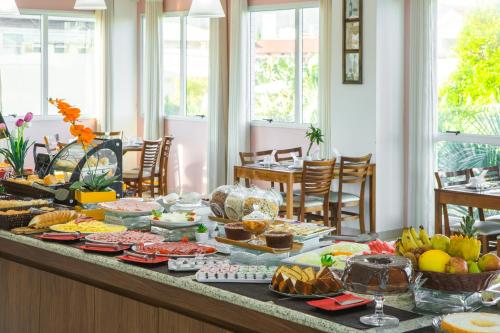 Oceania Park Hotel Spa & Convention في فلوريانوبوليس: بوفيه طعام على طاولة في الغرفة