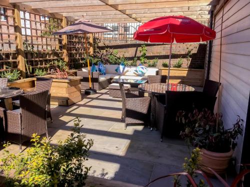 a patio with tables and chairs and an umbrella at The Angel Hotel in Alton