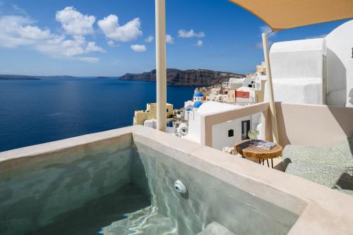 a view from a balcony of a beach with a view of the ocean at Canvas Suites in Oia