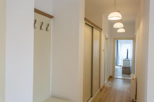 a hallway with white walls and wooden floors and a door at Pension Carmen`s Mansion A in Sinaia