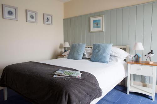 a bedroom with a large white bed with blue pillows at Seacroft in Holyhead