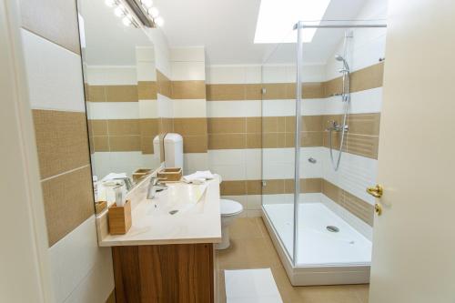 a bathroom with a shower and a sink and a tub at Pension Carmen`s Mansion A in Sinaia