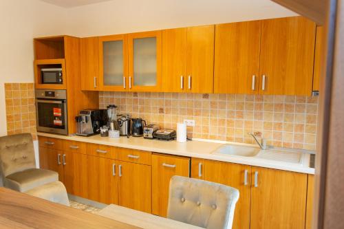 a kitchen with wooden cabinets and a sink at Pension Carmen`s Mansion A in Sinaia