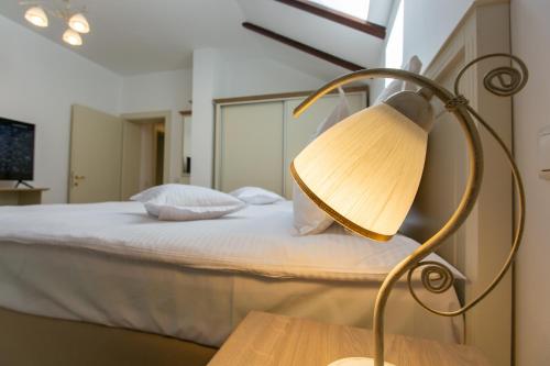 a lamp sitting on a table next to a bed at Pension Carmen`s Mansion A in Sinaia