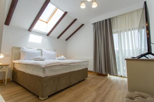 a bedroom with a large bed in a room with windows at Pension Carmen`s Mansion A in Sinaia