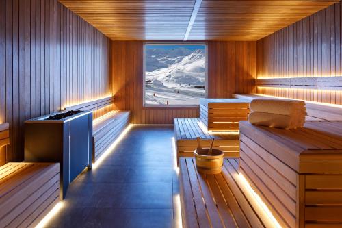 una sauna con pareti in legno, finestra e panche di Hôtel Marielle a Val Thorens