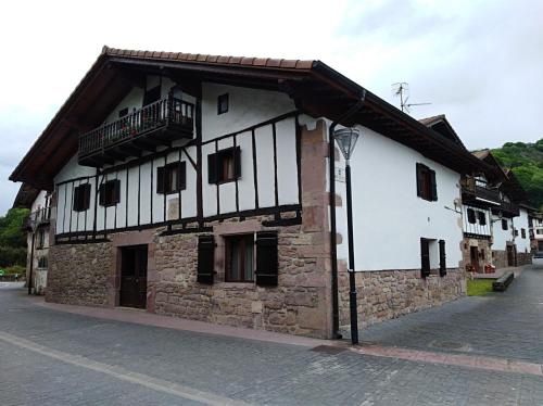 a building with a balcony on the side of it at Pedroenea Apartamento Elizondo in Elizondo