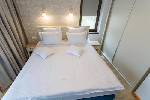 a large white bed in a small room at Pension Carmen`s Mansion A in Sinaia
