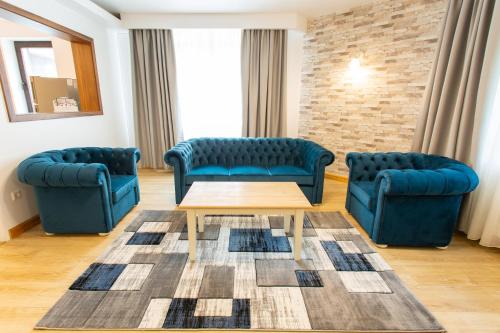 a waiting room with two blue chairs and a table at Pension Carmen`s Mansion A in Sinaia