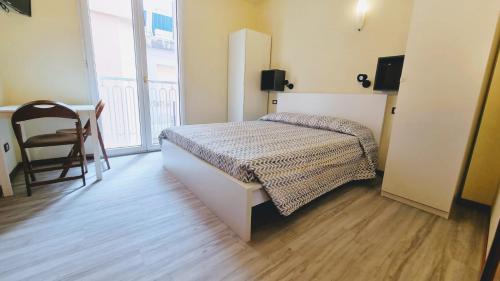 - une chambre avec un lit, une table et une chaise dans l'établissement Residence Rosa, à Gabicce Mare