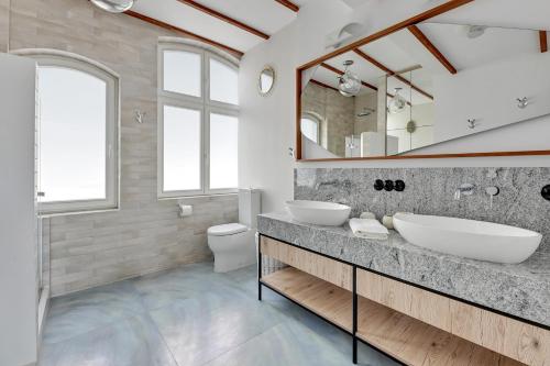 uma casa de banho com 2 lavatórios e um espelho em Lion Apartments - Sopot Cosy Attic em Sopot