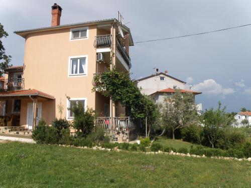 una gran casa en una colina con un patio en Apartment Akaju, en Rovinjsko Selo