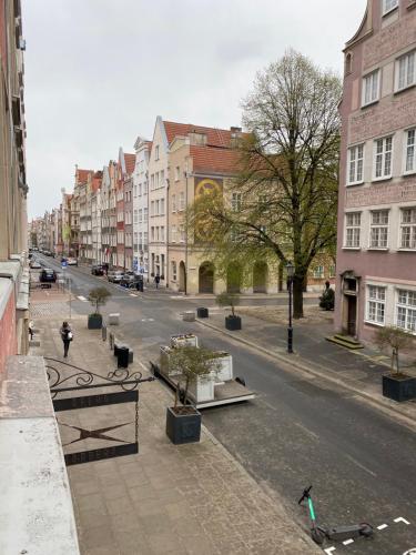 an empty city street with buildings and trees at Apartament Gdańsk Centrum Old Town in Gdańsk