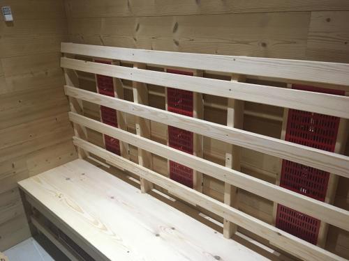 a wooden shelf with red glass in a room at Hôtel Le Cassini in Le Freney-dʼOisans