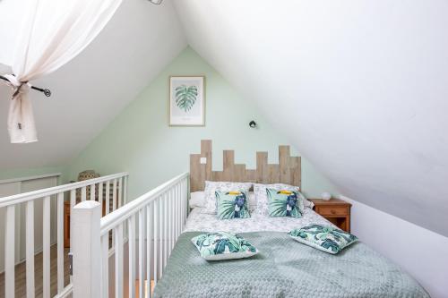 - une chambre avec un lit bébé et un lit avec des oreillers dans l'établissement Le Cosy, à Lanvallay