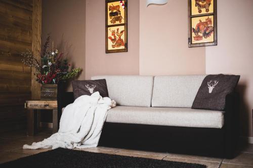 un soggiorno con divano e coperta di Residence Les Fleurs a Pila