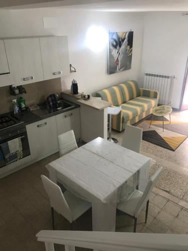 cocina y sala de estar con mesa blanca y sillas en I colori della Tuscia, en Caprarola