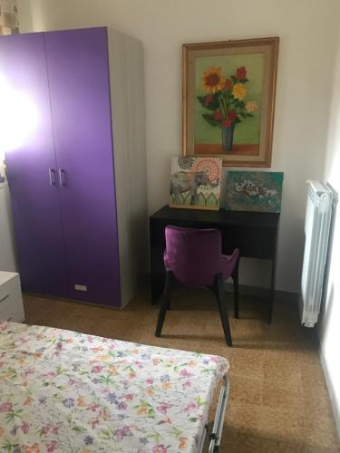 ein Schlafzimmer mit einem lila Schrank und einem Schreibtisch in der Unterkunft I colori della Tuscia in Caprarola