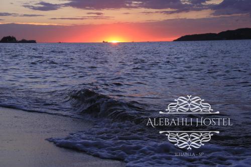 a sunset on the beach with the ocean at Alebahli Hospedagem Ilhabela in Ilhabela