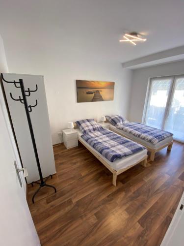two beds in a room with wooden floors at Apartment - Wohnung bei Nürnberg #1 in Röthenbach an der Pegnitz