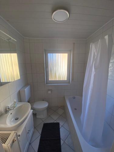 a bathroom with a tub and a toilet and a sink at Apartment - Wohnung bei Nürnberg #1 in Röthenbach an der Pegnitz
