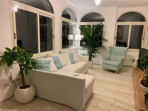 a living room with a white couch and chairs at Sky House Amalfi Coast in Scala