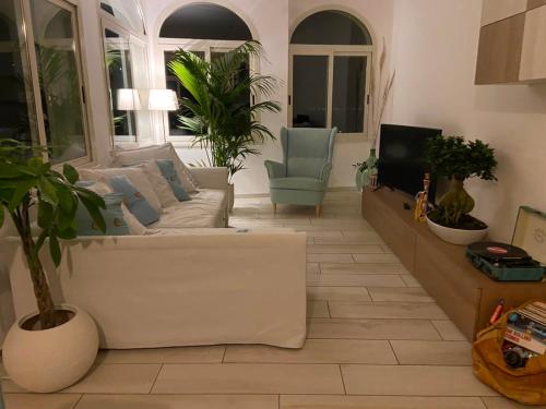 a living room with a white couch and a tv at Sky House Amalfi Coast in Scala