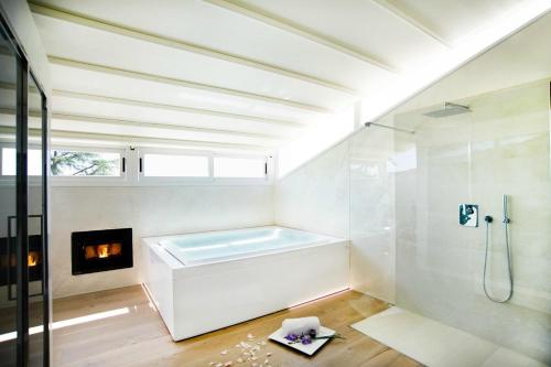 a white bathroom with a tub and a fireplace at Villa La Grotta in San Giustino Valdarno