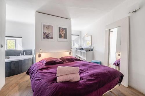 Cette chambre comprend un grand lit violet et un lavabo. dans l'établissement Le Duplex tropézienne par Dodo-a-Cassis, à Cassis