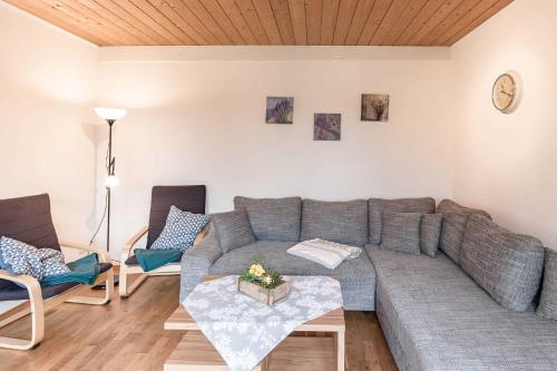 sala de estar con sofá gris y sillas en Eider Domizil No 2, en Oldenswort