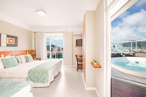 a hotel room with a bed and a bathtub at Oceania Park Hotel Spa & Convention by RB Hotelaria in Florianópolis