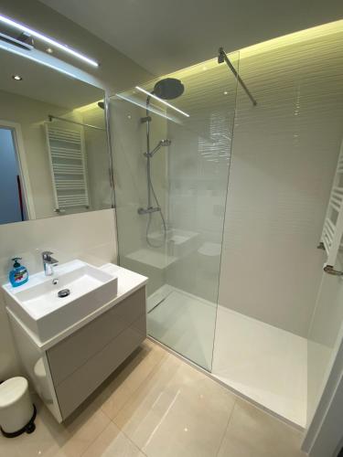 a white bathroom with a shower and a sink at Flat4You in Poznań