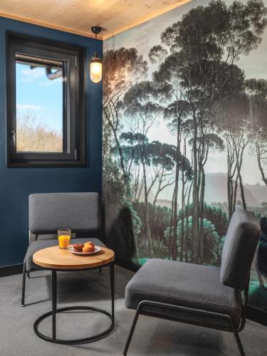 a room with two chairs and a table and a painting at Eklo Marne La Vallée in Serris