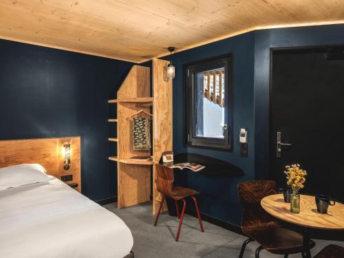 a bedroom with a bed and a desk and a table at Eklo Marne La Vallée in Serris
