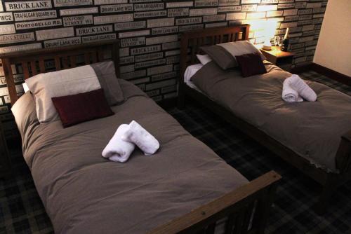 two beds in a room with towels on them at The Castle Inn in Dirleton