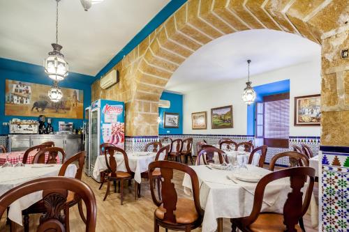 een restaurant met tafels en stoelen in een kamer met blauwe muren bij Hostal El Caballo Blanco in Osuna