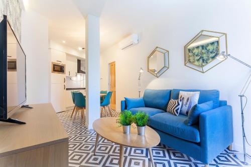 a living room with a blue couch and a table at Rio Plaza en Madrid in Madrid
